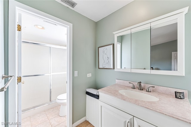 bathroom with tile patterned floors, vanity, toilet, and walk in shower