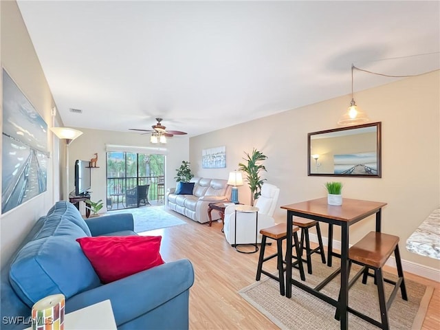 living room with ceiling fan and light hardwood / wood-style flooring