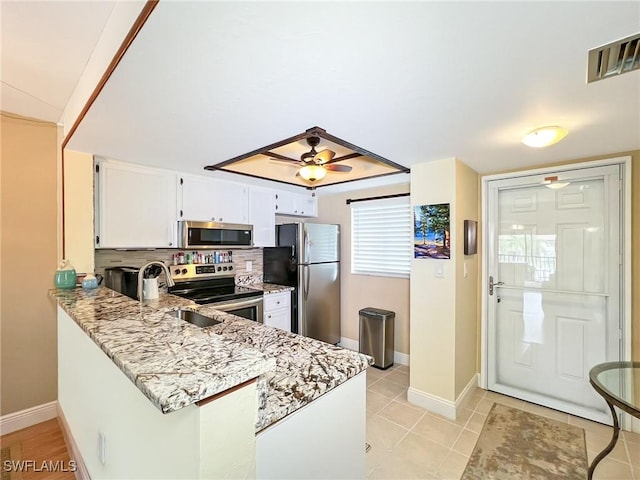 kitchen with ceiling fan, white cabinetry, light stone counters, light tile patterned floors, and appliances with stainless steel finishes