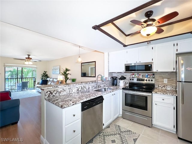 kitchen featuring white cabinetry, stainless steel appliances, and decorative light fixtures