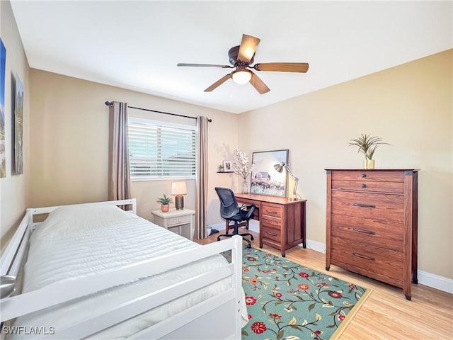 bedroom featuring light hardwood / wood-style floors, ceiling fan, and a baseboard heating unit