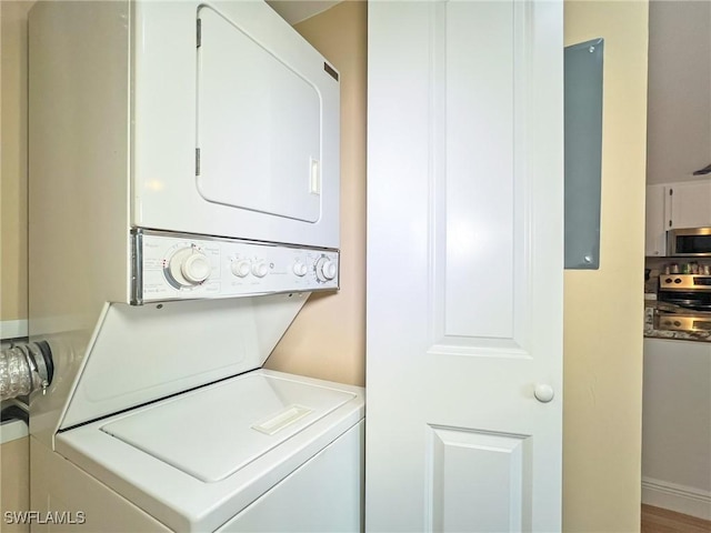 washroom featuring stacked washer and clothes dryer