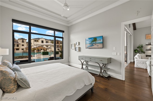 bedroom featuring ceiling fan, dark wood-type flooring, crown molding, and a tray ceiling