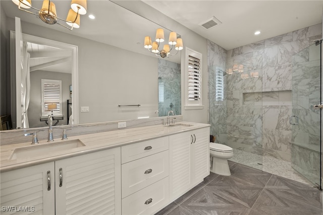 bathroom with toilet, an inviting chandelier, an enclosed shower, and vanity