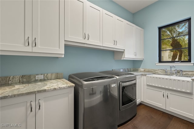 washroom featuring sink, dark hardwood / wood-style floors, independent washer and dryer, and cabinets