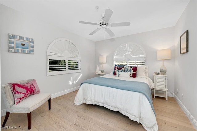 bedroom featuring ceiling fan, light wood-style flooring, and baseboards