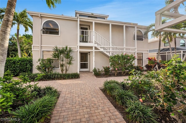 view of front of property featuring stairway and stucco siding