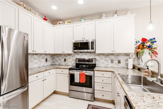 kitchen featuring stainless steel appliances, backsplash, decorative light fixtures, white cabinets, and sink