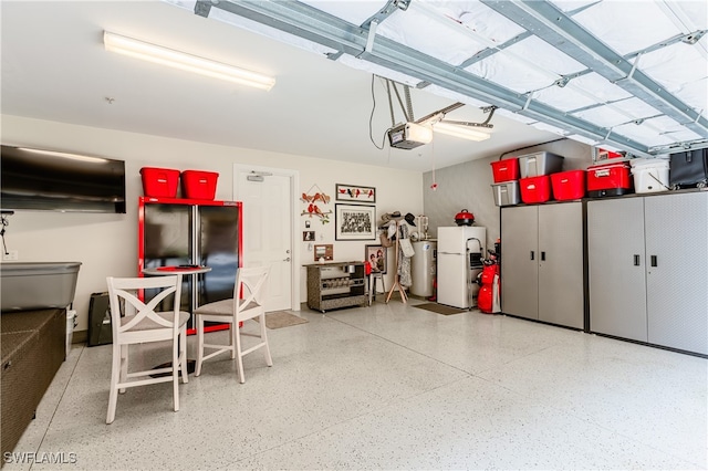 garage with black refrigerator, white refrigerator, water heater, and a garage door opener