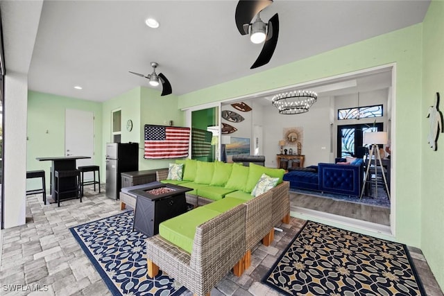 living room featuring ceiling fan with notable chandelier