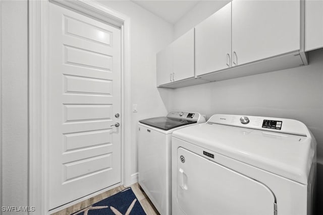 laundry area with washer and clothes dryer and cabinets