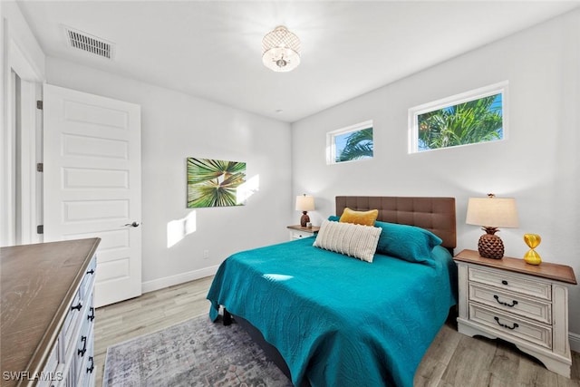 bedroom with light wood-type flooring and multiple windows