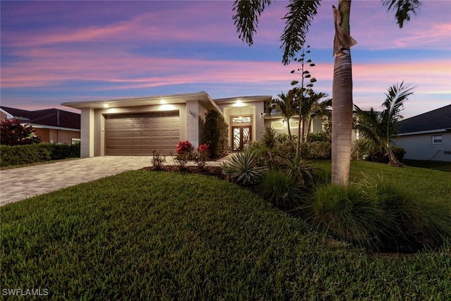 view of front of home featuring a lawn and a garage