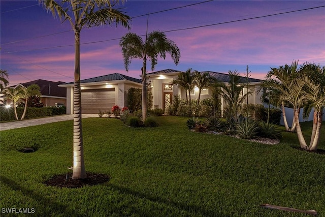 view of front of home with a garage and a yard