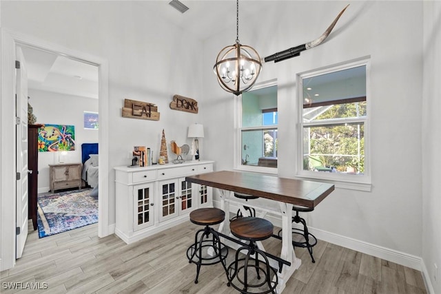 dining room with a chandelier and light hardwood / wood-style flooring