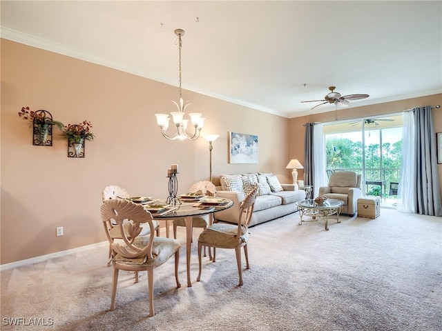 dining space with ceiling fan with notable chandelier, carpet floors, and ornamental molding