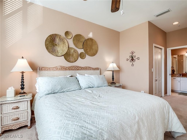 bedroom featuring connected bathroom, ceiling fan, and light carpet