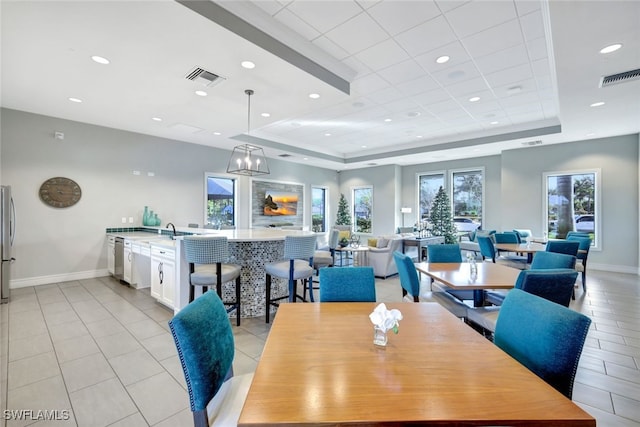 dining area featuring a raised ceiling and sink