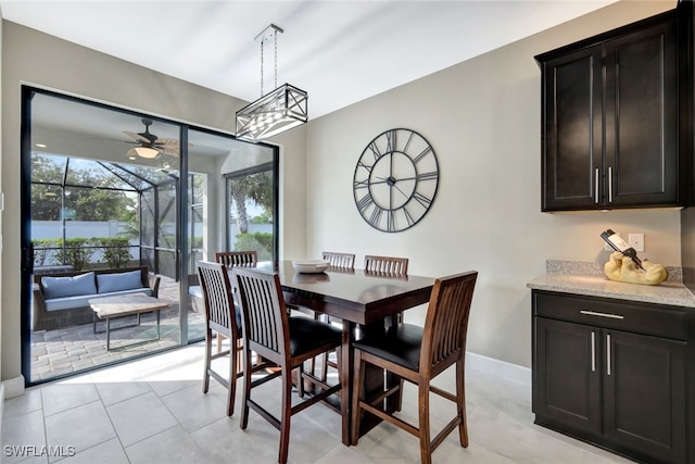 tiled dining room with ceiling fan with notable chandelier