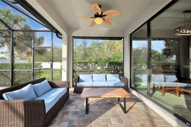 sunroom featuring ceiling fan with notable chandelier