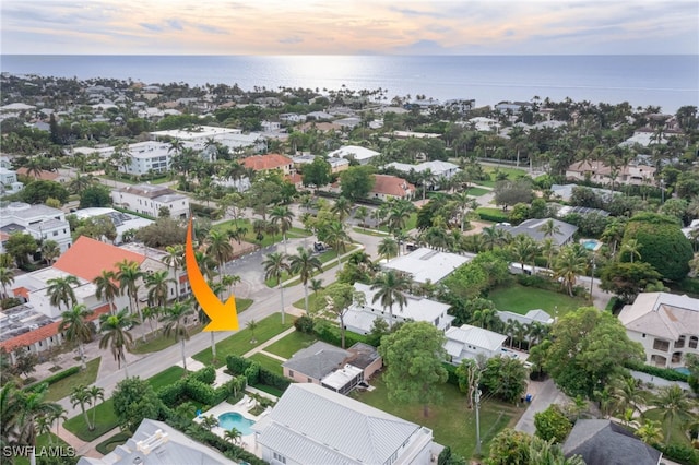 aerial view at dusk featuring a water view