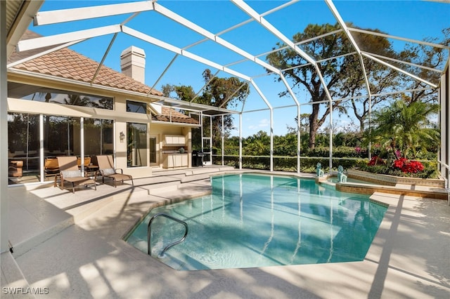 view of swimming pool featuring a lanai, exterior kitchen, and a patio