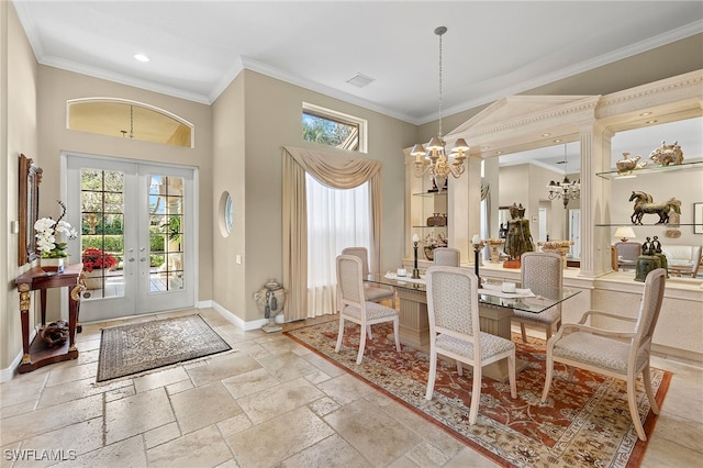 dining room featuring a notable chandelier, ornamental molding, a towering ceiling, and french doors