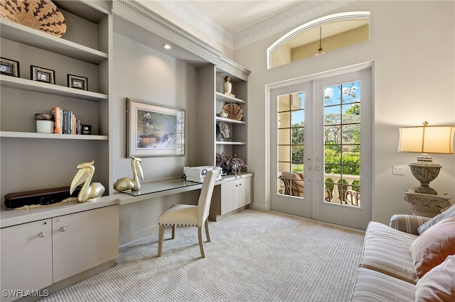 home office featuring built in shelves, light carpet, french doors, and crown molding