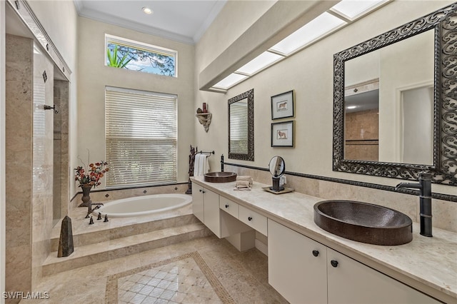 bathroom featuring vanity, crown molding, and tiled bath