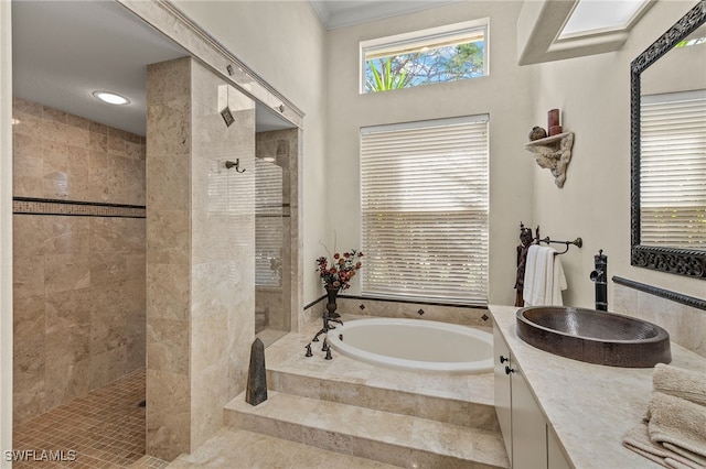 bathroom featuring plus walk in shower, vanity, and a healthy amount of sunlight