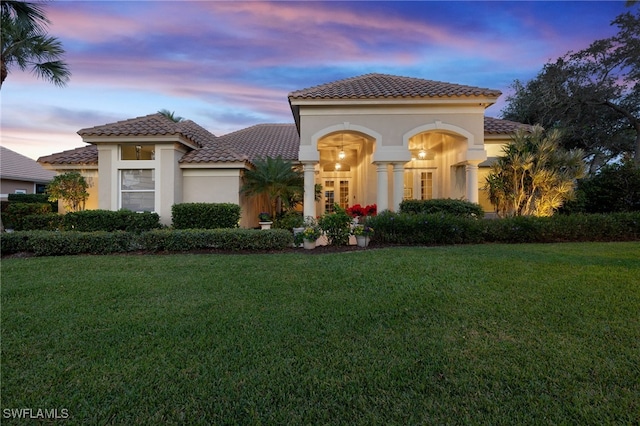 mediterranean / spanish-style house with a yard