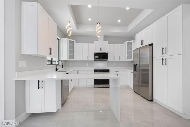 kitchen with stainless steel appliances, light countertops, glass insert cabinets, white cabinetry, and a sink