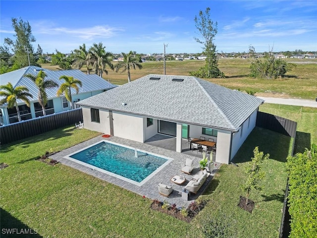 back of house featuring a lawn, a fenced backyard, a patio area, outdoor lounge area, and stucco siding