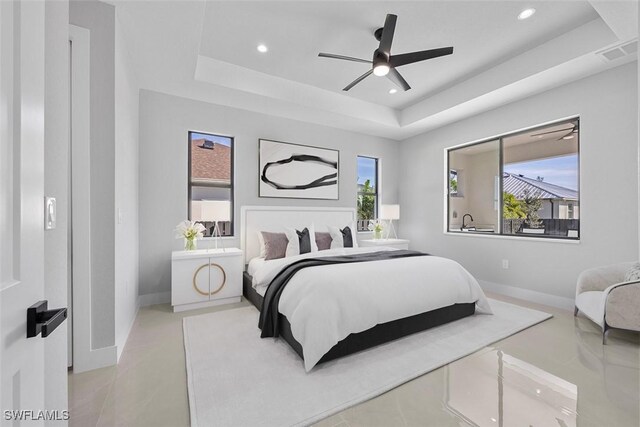 bedroom with visible vents, multiple windows, a tray ceiling, and recessed lighting