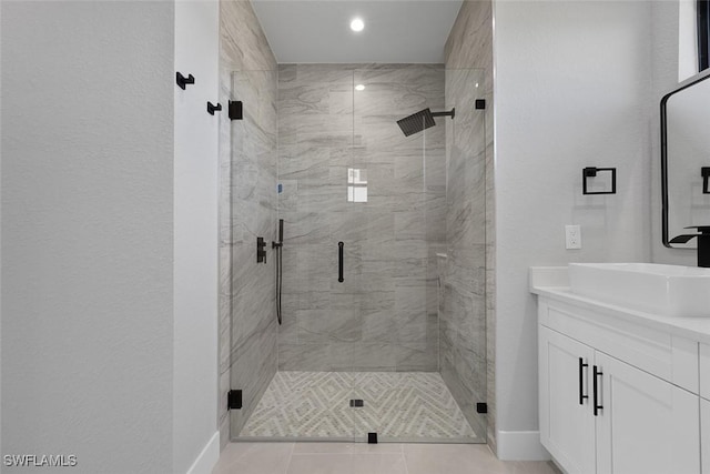 full bath featuring a shower stall, vanity, and baseboards