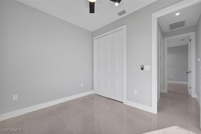 unfurnished bedroom with ceiling fan, a closet, visible vents, and baseboards