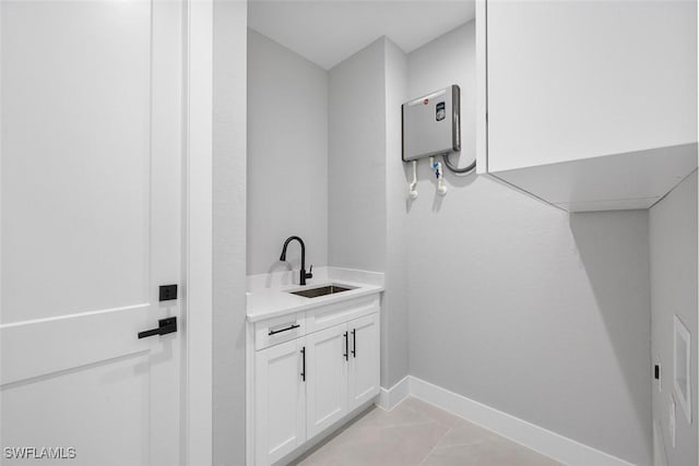 bathroom featuring tile patterned flooring, a sink, and baseboards