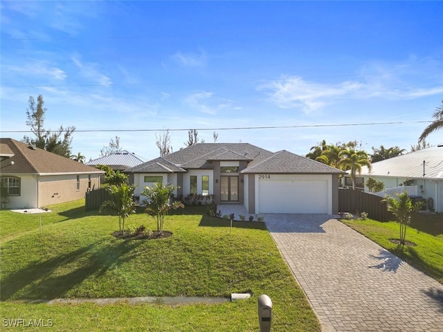 view of front of home with a garage, fence, decorative driveway, and a front yard