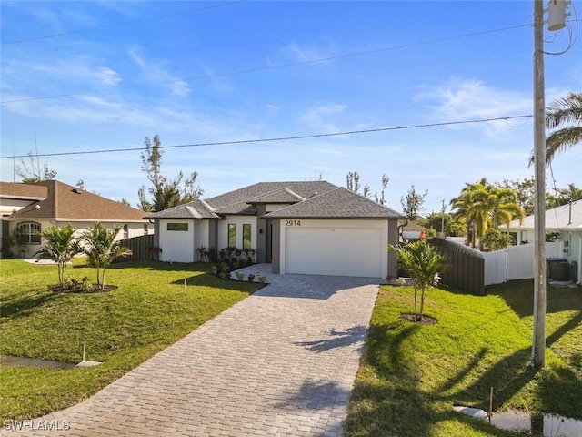 view of front of house with a garage, fence, decorative driveway, stucco siding, and a front lawn