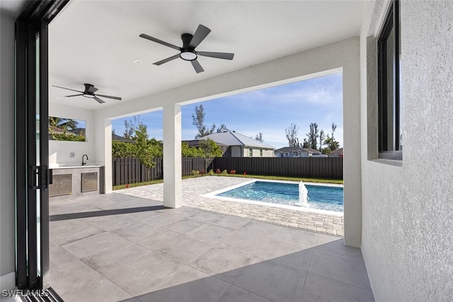 view of pool featuring a patio area, a fenced backyard, and exterior kitchen