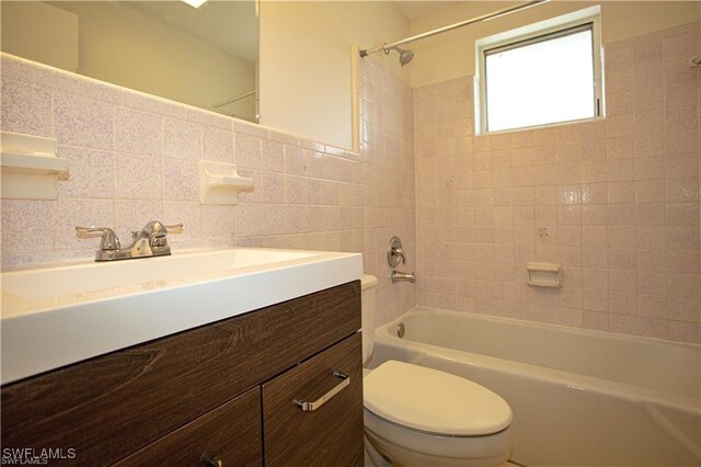 full bathroom featuring tasteful backsplash, vanity, tile walls, toilet, and tiled shower / bath