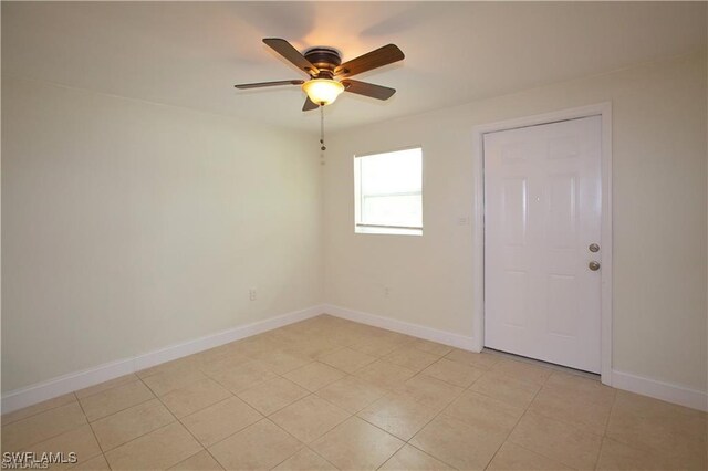 tiled spare room with ceiling fan