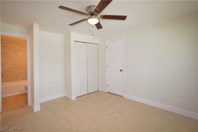 unfurnished bedroom featuring ceiling fan, a closet, and ensuite bath