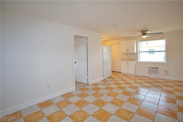 unfurnished room with a wall unit AC and ceiling fan