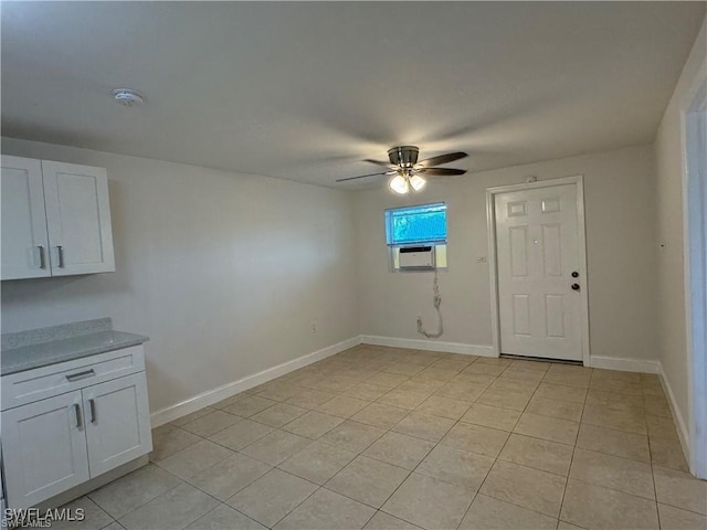 interior space with ceiling fan, cooling unit, and light tile patterned flooring