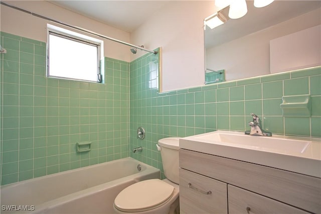 full bathroom featuring vanity, backsplash, tiled shower / bath, toilet, and tile walls