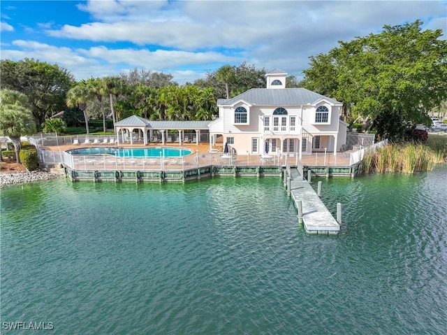 back of house featuring a balcony, a water view, and a patio