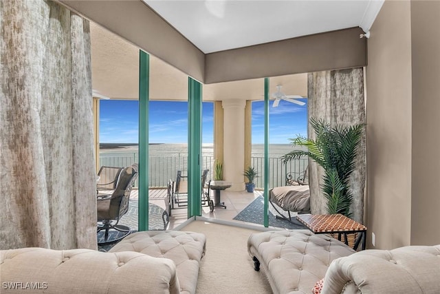 sunroom / solarium featuring a water view, plenty of natural light, and ceiling fan