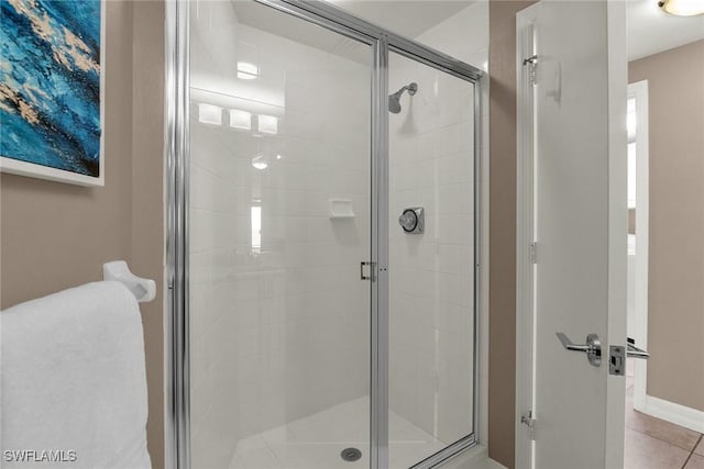 bathroom with tile patterned flooring and a shower with shower door