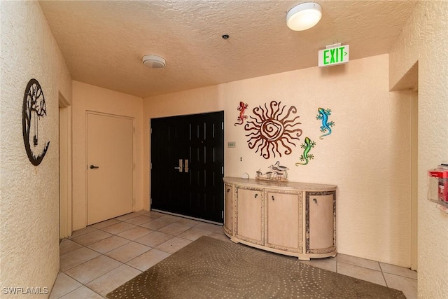 tiled foyer entrance featuring a textured ceiling